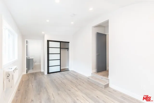a view of empty room with wooden floor