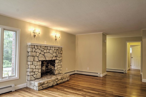 23 Hunt Road Westford, MA 01886 - Photo 14 of 27 a view of a livingroom with wooden floor and a fireplace