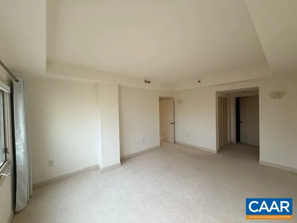 an empty room with a fireplace and windows