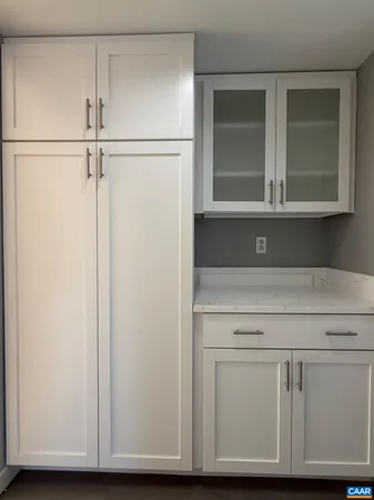 a view of kitchen with white cabinets and a refrigerator