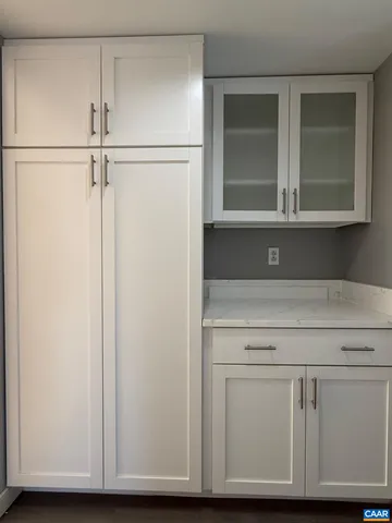 a view of kitchen with white cabinets and a refrigerator