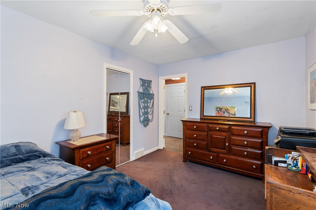 1256 Garman Road Akron, OH 44313 - Photo 15 of 32 Bedroom featuring a closet, ceiling fan, and dark colored carpet