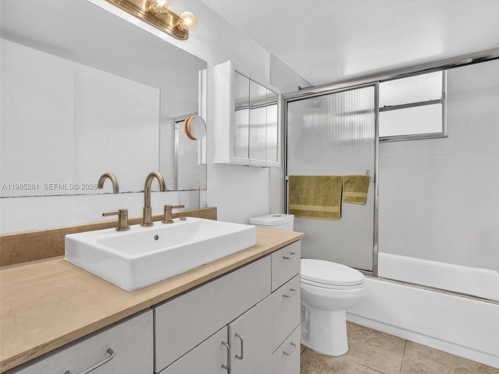 1236 Alton Road, Unit 304 Miami Beach, FL 33139 - Photo 16 of 28 a bathroom with a sink toilet and shower