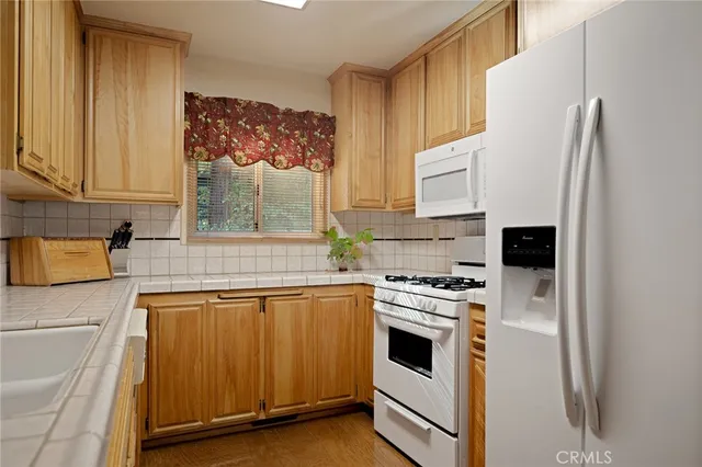 a kitchen with white cabinets and white appliances