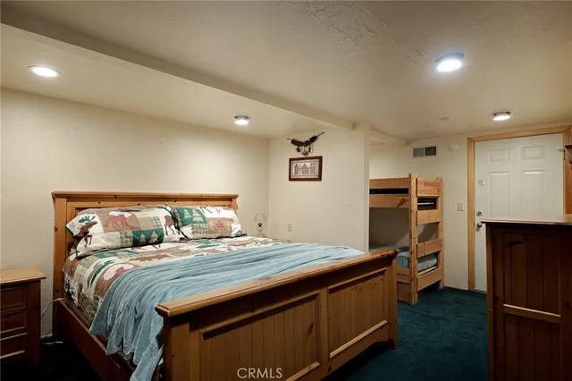 a bedroom with a bed and a refrigerator