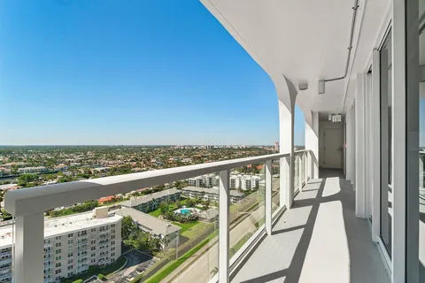 a view of a balcony with wooden floor & fence