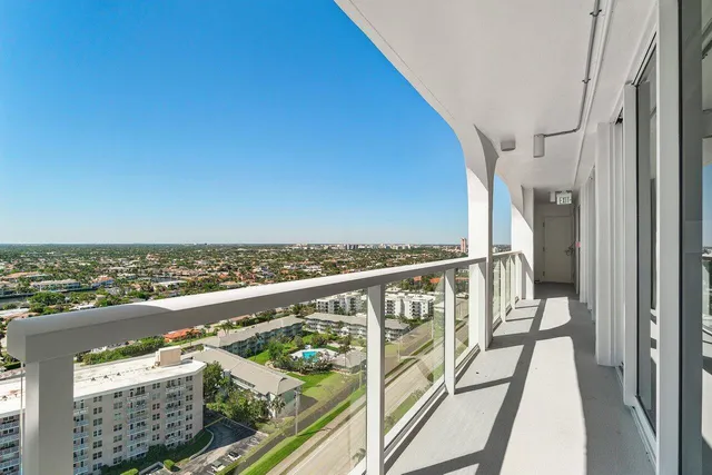 a view of a balcony with wooden floor & fence