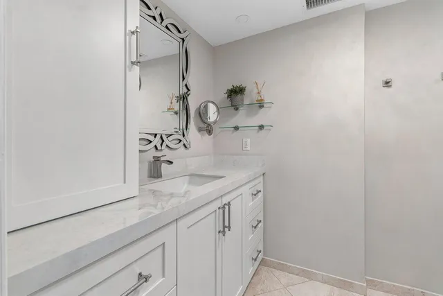 a bathroom with a granite countertop sink and a mirror