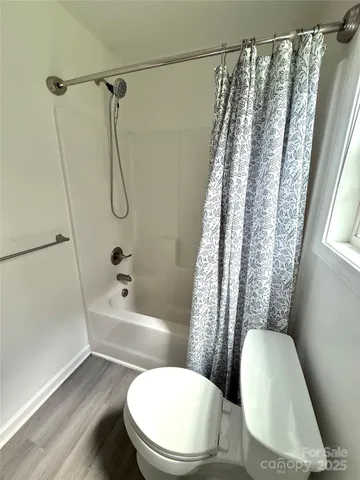 a white toilet sitting next to a bath tub shower