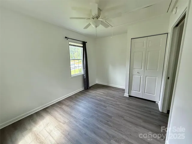 an empty room with wooden floor and a window