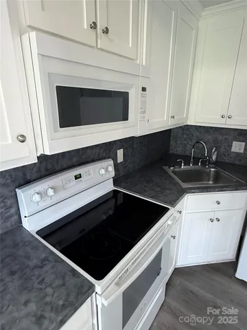 a kitchen with white cabinets and black appliances