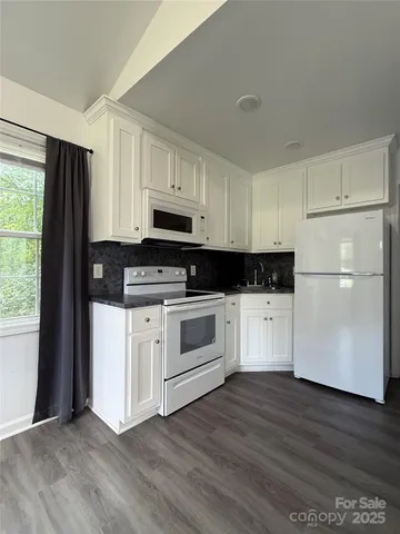 a kitchen with stainless steel appliances white cabinets and a refrigerator