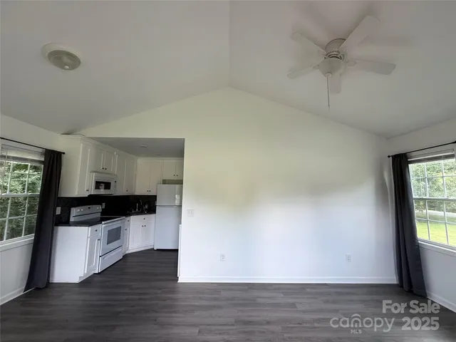 a kitchen with granite countertop a stove a sink and a refrigerator