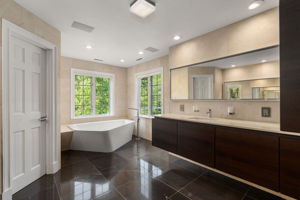 69 Princeton Road Brookline, MA 02467 - Photo 18 of 28 a large bathroom with a large tub sink and mirror