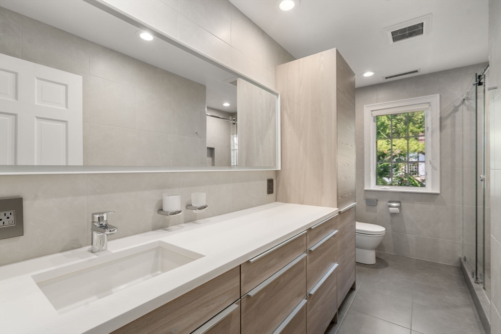 69 Princeton Road Brookline, MA 02467 - Photo 22 of 28 a bathroom with a sink double vanity and a toilet