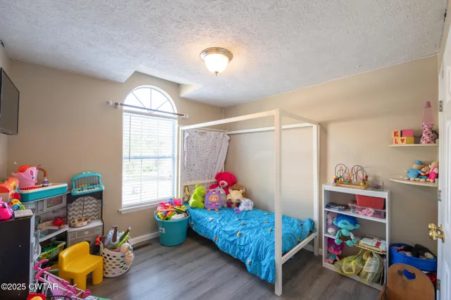 a living room with baby crib furniture and a window