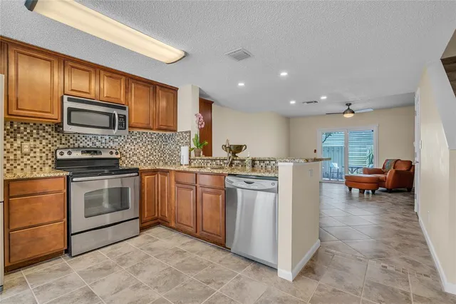 a kitchen with stainless steel appliances granite countertop a sink and a refrigerator