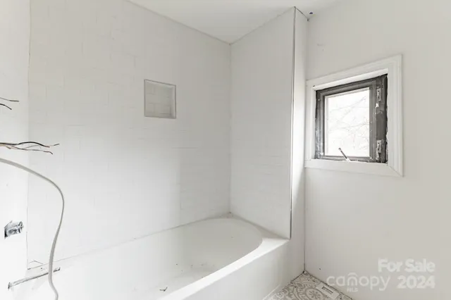 a living room with a couch and a window with wooden floor