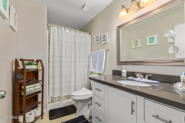 a bathroom with a granite countertop sink toilet and shower