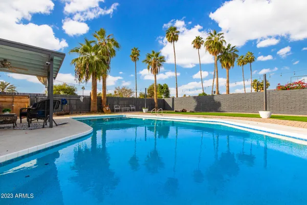 a view of swimming pool with outdoor seating and a patio