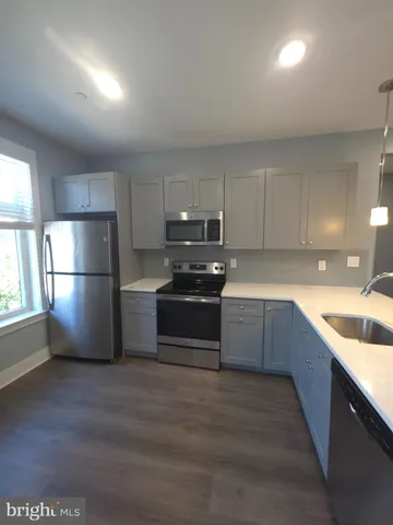 a kitchen with granite countertop a refrigerator and a sink