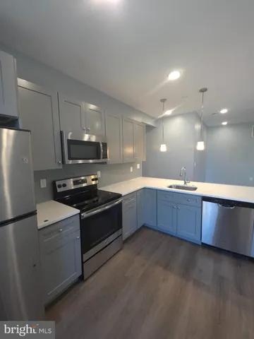 a kitchen with stainless steel appliances granite countertop a stove a sink dishwasher a refrigerator and a microwave