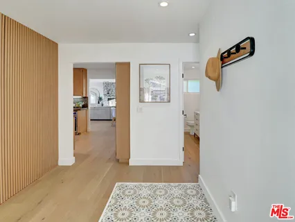 a view of a hallway with bathroom and wooden floor