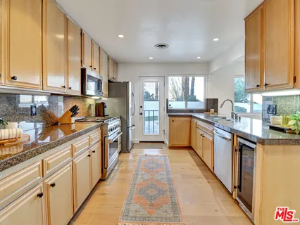 a kitchen with stainless steel appliances granite countertop lots of counter top space a sink and cabinets