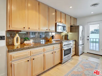 a kitchen with stainless steel appliances granite countertop a refrigerator sink and cabinets