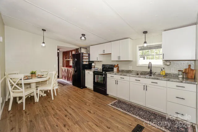 a kitchen with a sink white cabinets and stainless steel appliances