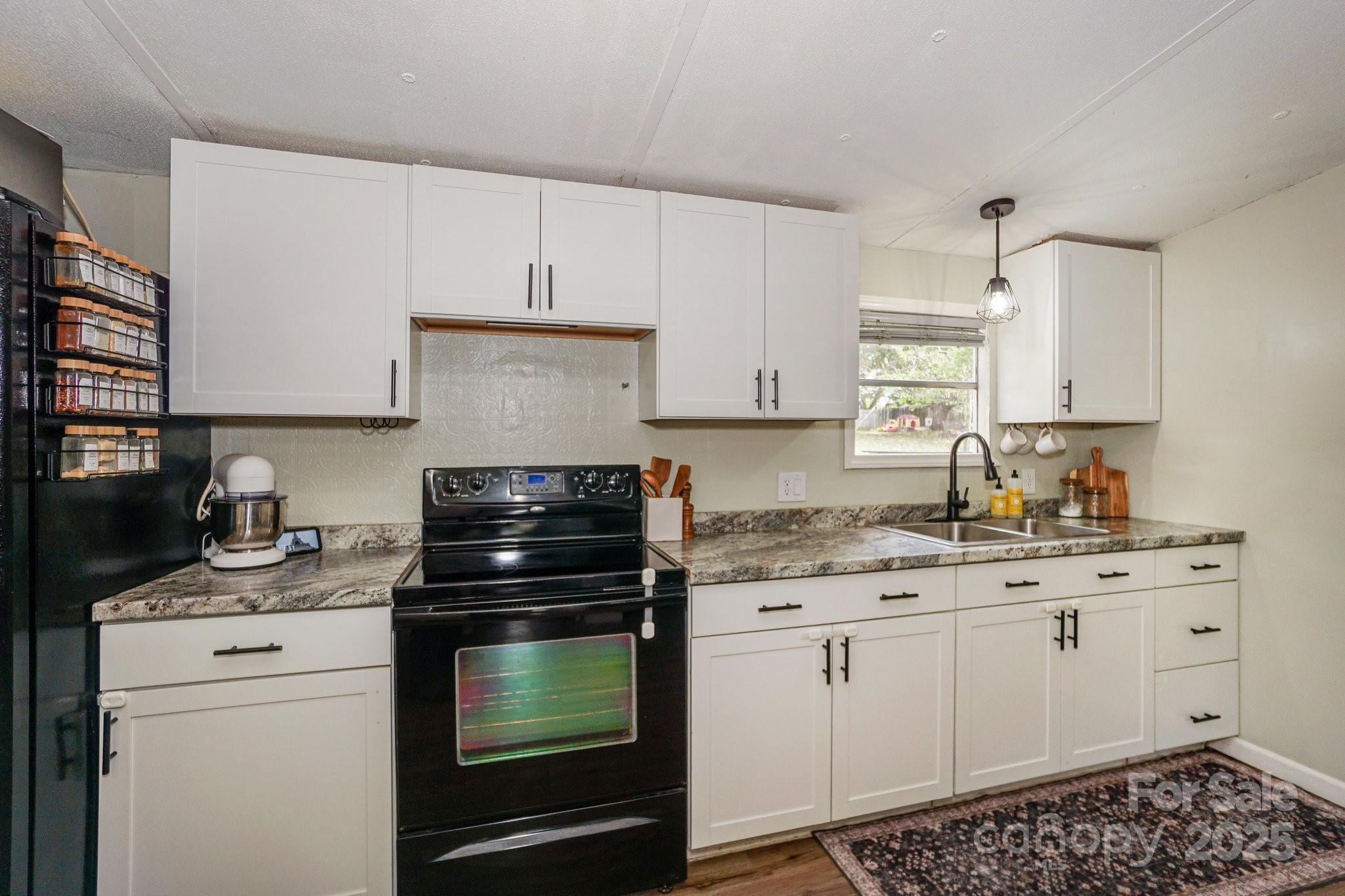1279 Craig Drive Iron Station, NC 28080 - Photo 18 of 47 a kitchen with granite countertop a stove sink and cabinets