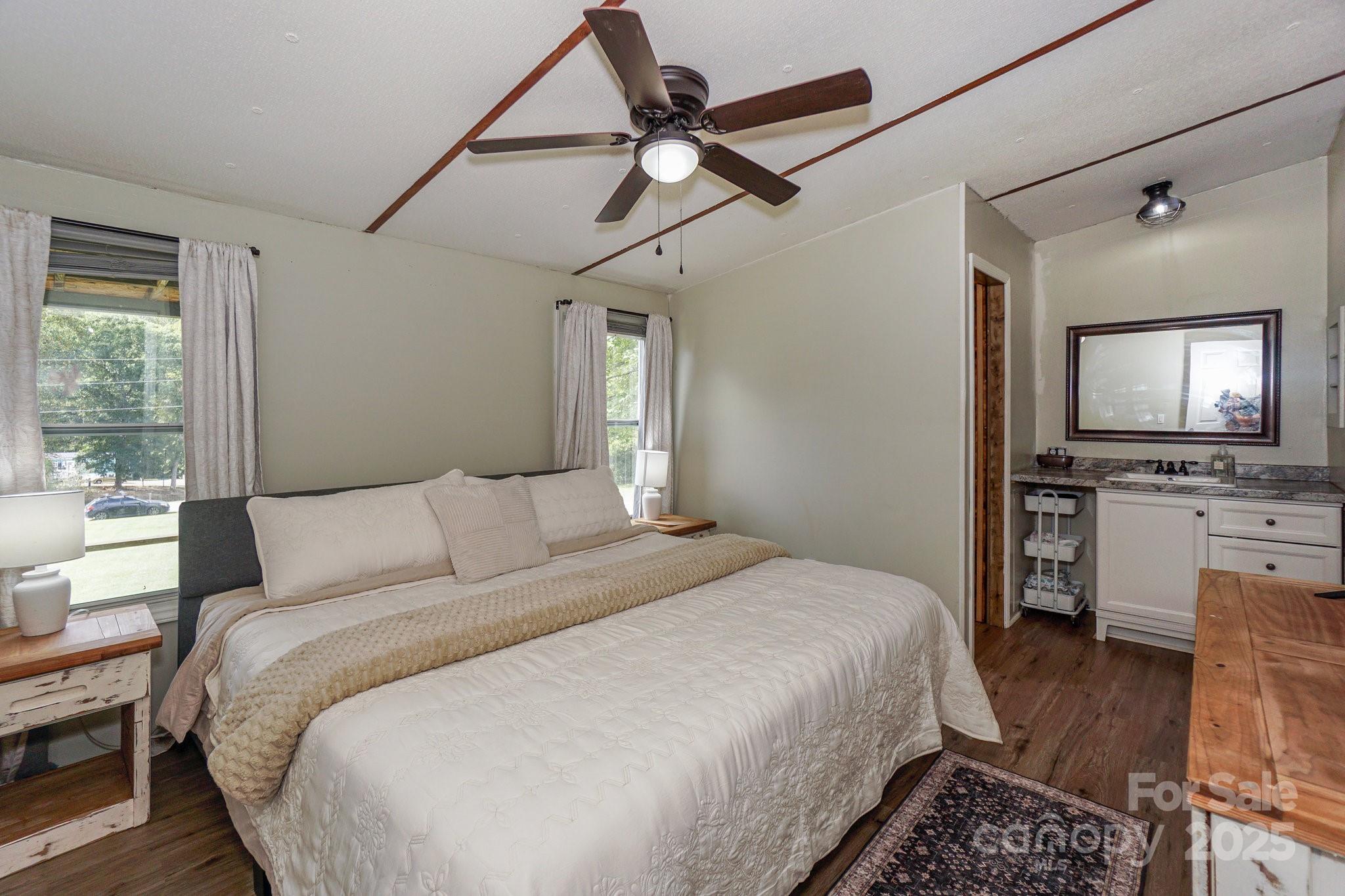 1279 Craig Drive Iron Station, NC 28080 - Photo 21 of 47 a spacious bedroom with a bed a dresser and flat screen tv
