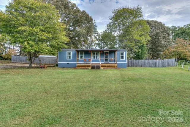 front view of a house with a yard and a large tree