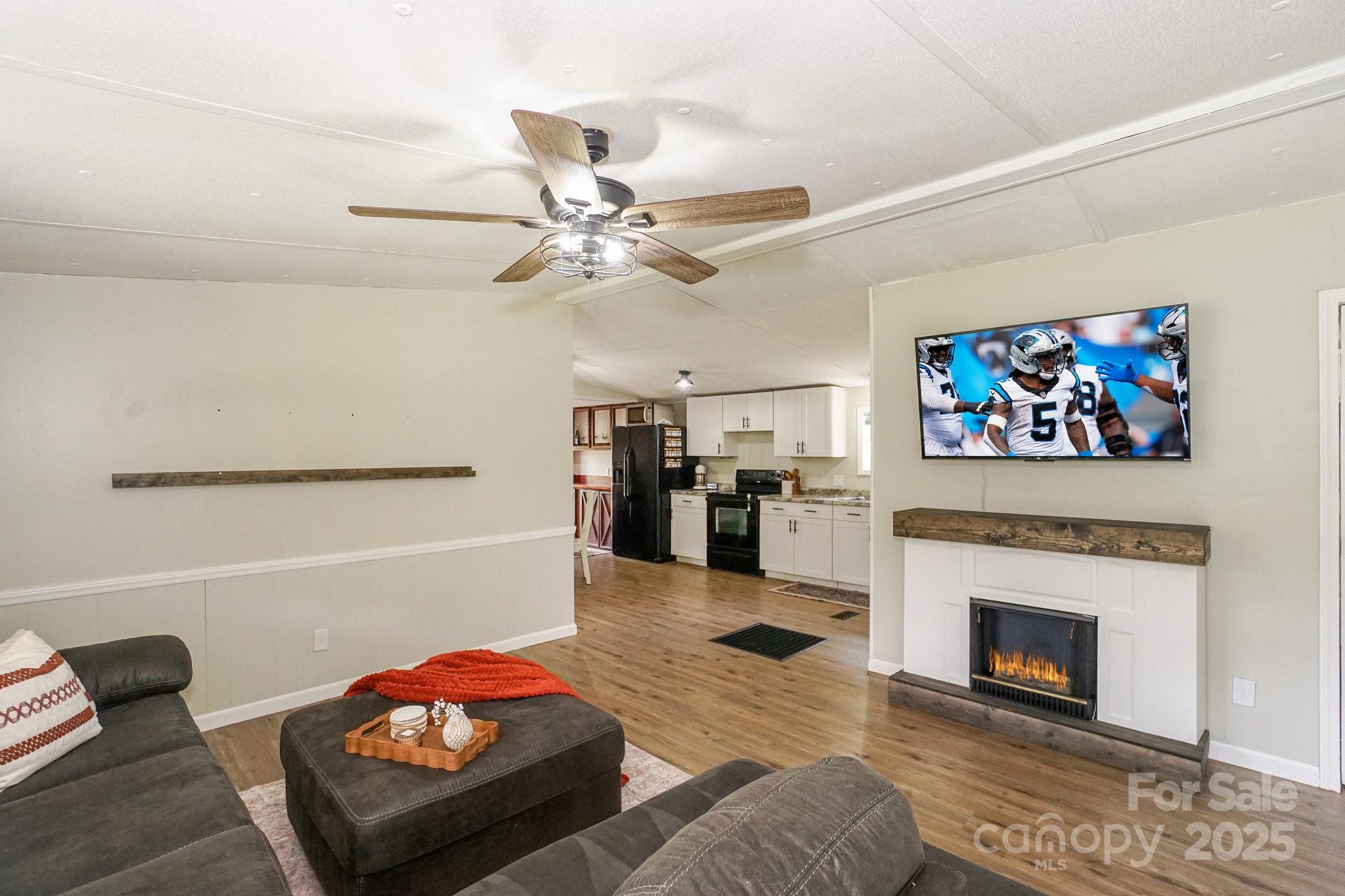 1279 Craig Drive Iron Station, NC 28080 - Photo 9 of 47 a living room with furniture a fireplace and a flat screen tv