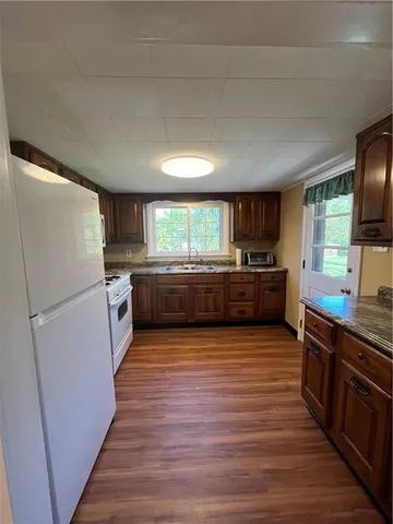 a large kitchen with wooden floors and stainless steel appliances