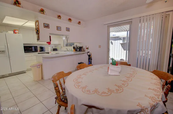 a white kitchen with a stove a sink and a refrigerator