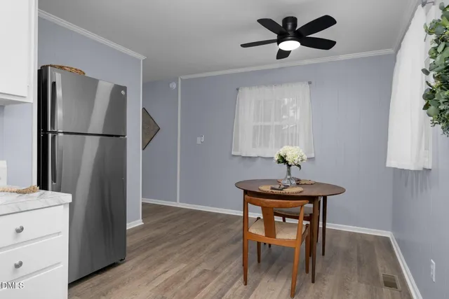 a kitchen with a table chairs refrigerator and cabinets