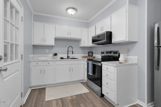 a kitchen with cabinets stainless steel appliances and a sink