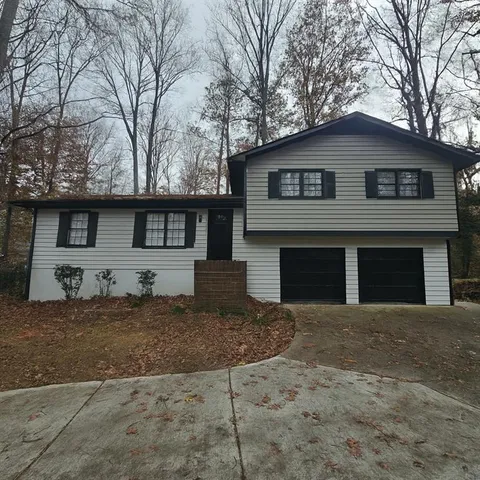 a front view of a house with yard and trees