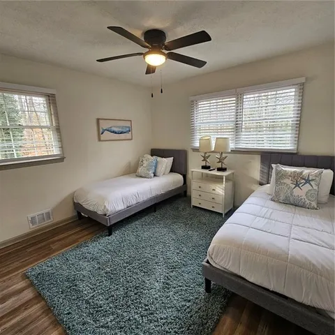a bedroom with two beds and a large window