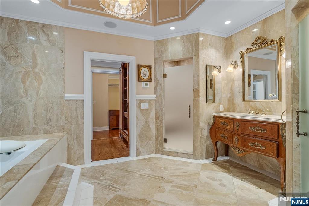 294 Oakwood Road Englewood, NJ 07631 - Photo 34 of 50 a bathroom with a sink a vanity a mirror and a bathtub