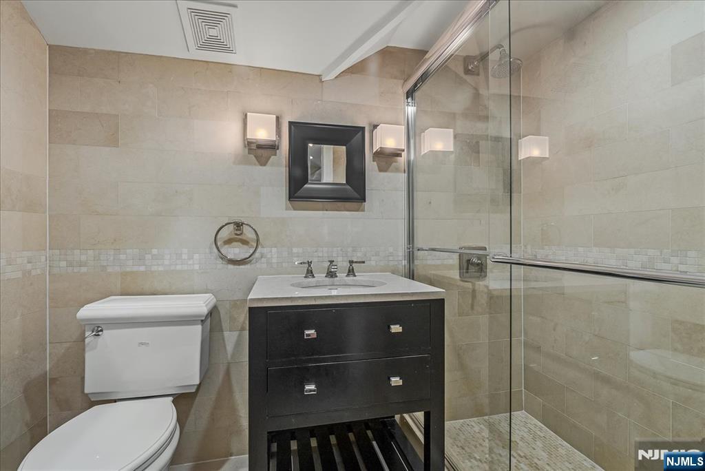 294 Oakwood Road Englewood, NJ 07631 - Photo 41 of 50 a bathroom with a toilet a sink and mirror