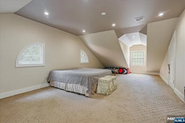 a spacious bedroom with a bed and a chandelier
