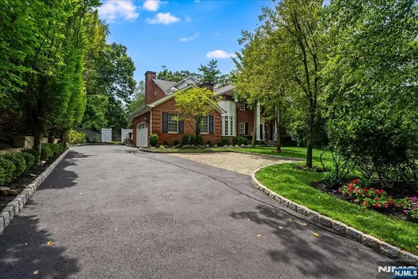 a front view of a house with a yard and trees
