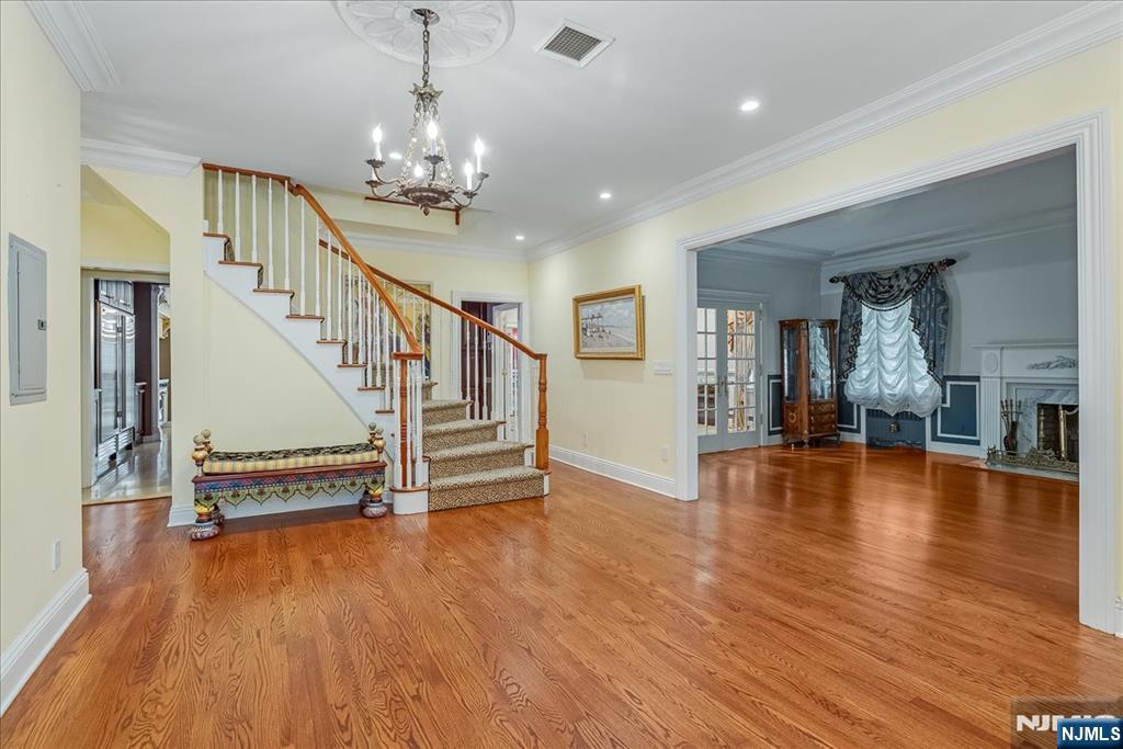 294 Oakwood Road Englewood, NJ 07631 - Photo 5 of 50 a view of an entryway with wooden floor stairs and a chandelier