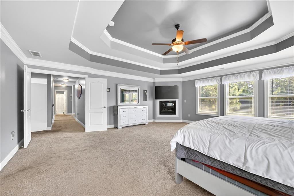2300 Tucker Mill Road Southwest Conyers, GA 30094 - Photo 19 of 45 a spacious bedroom with a large bed closet and chandelier