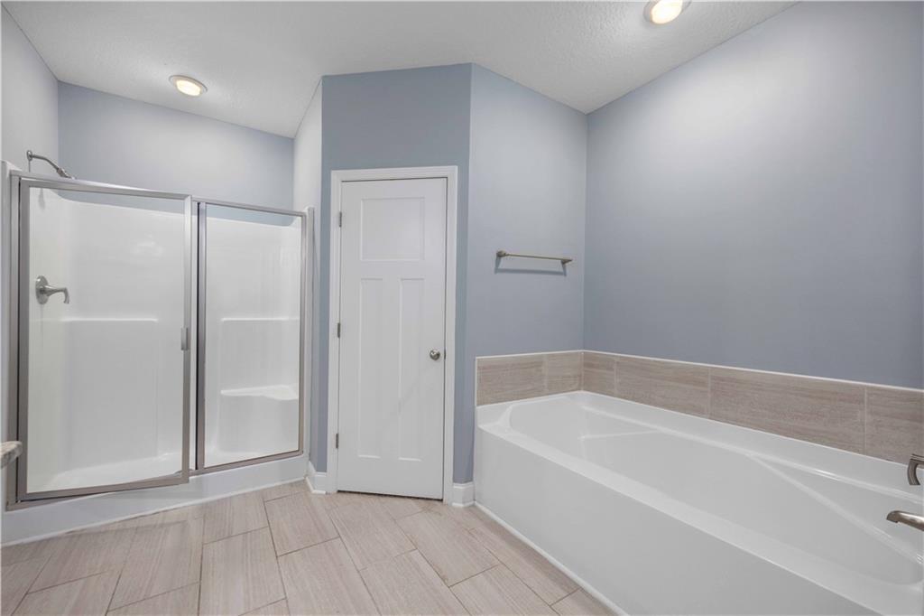 70 Apache Trail Fort Mitchell, AL 36856 - Photo 9 of 33 Bathroom featuring a shower stall, a garden tub, and a textured ceiling