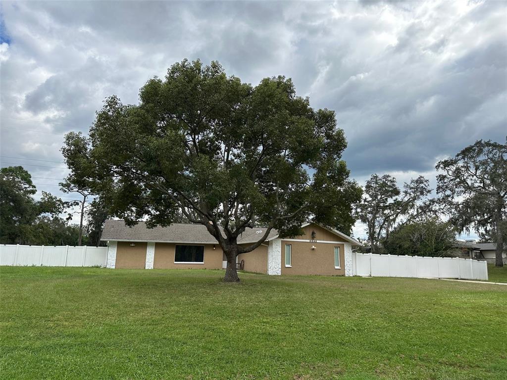 a front view of house with yard and trees in the background