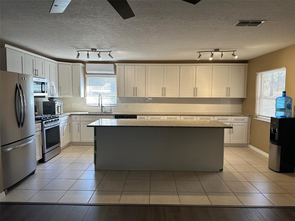 6848 Copperfield Drive New Port Richey, FL 34655 - Photo 11 of 20 a kitchen with stainless steel appliances granite countertop a stove a sink and a refrigerator