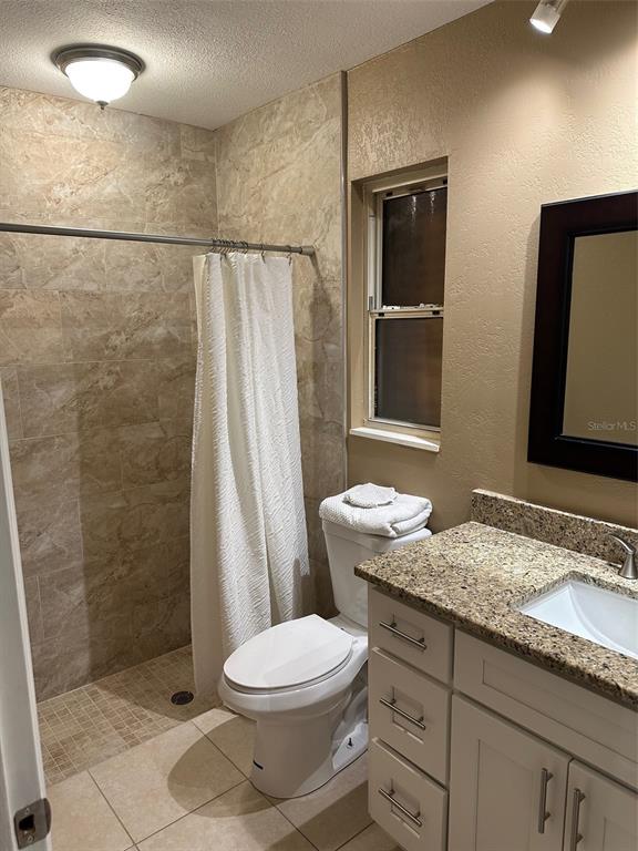 6848 Copperfield Drive New Port Richey, FL 34655 - Photo 3 of 20 a bathroom with a granite countertop sink a mirror and a toilet